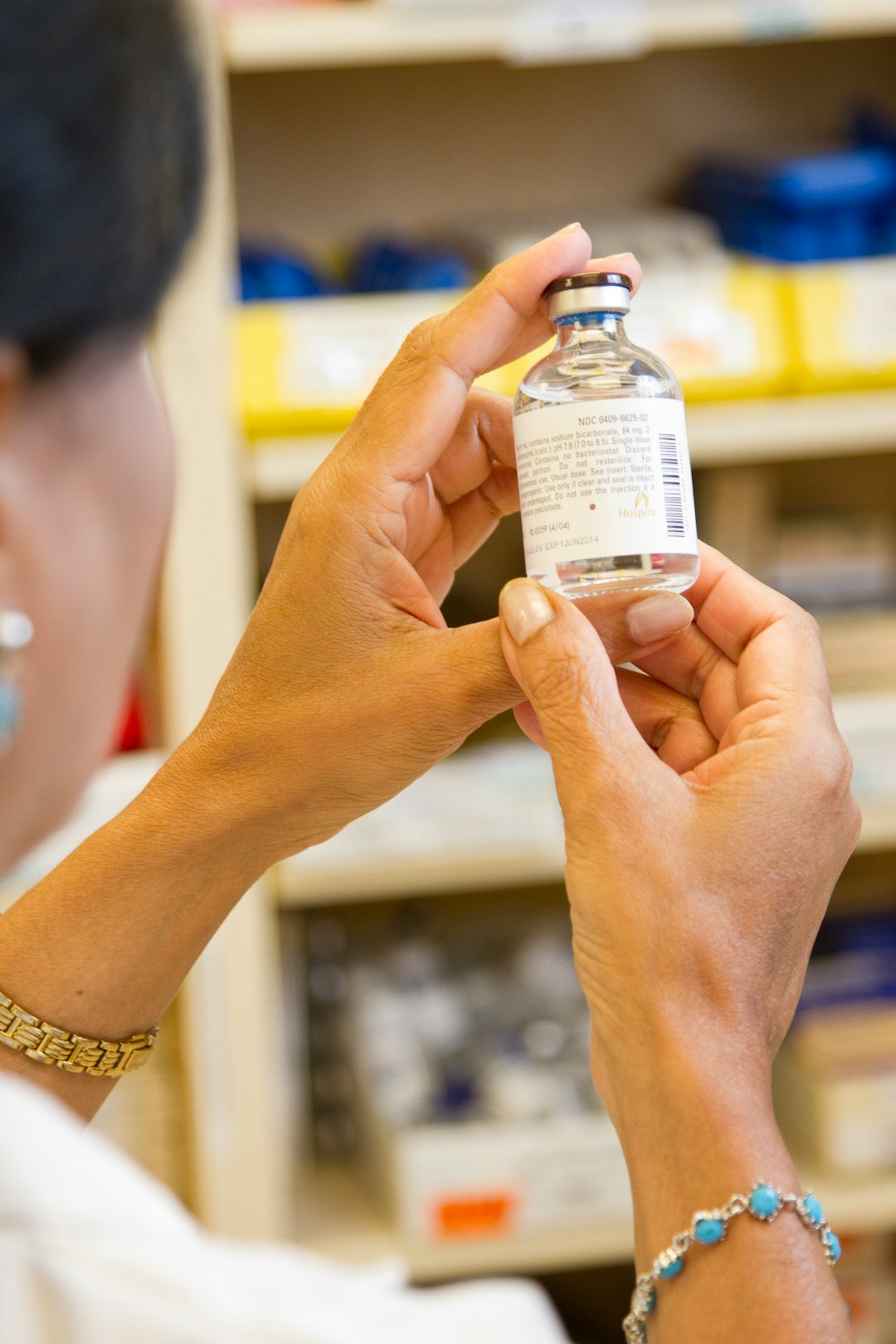 our-services-2 A female pharmacist is examining a vial in a pharmacy.